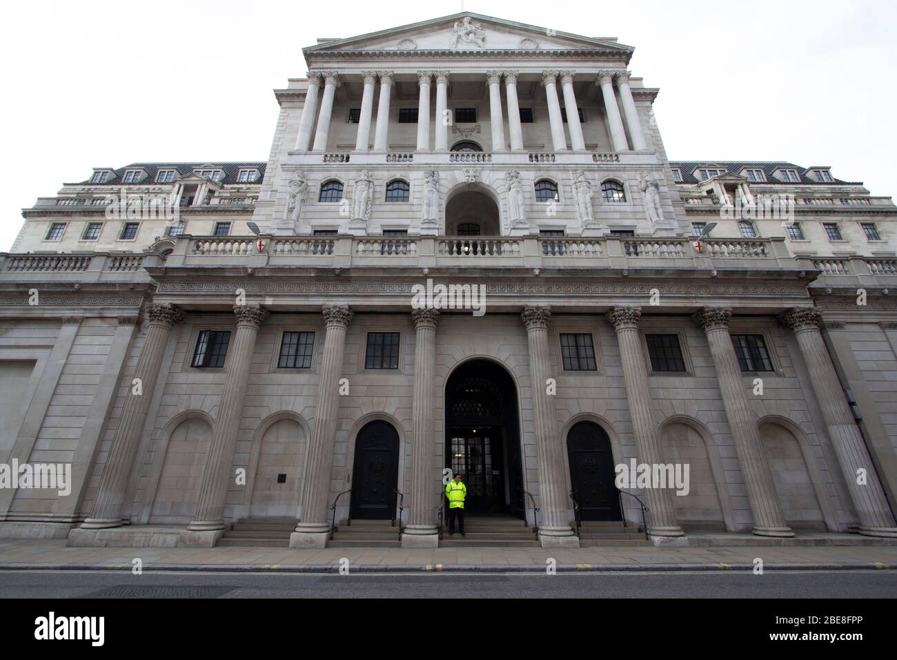 Security guard stands outside the Bank of England in the City of London, the streets where empty due to the Coronavirus Covid 19 lockdown. Stock Photo