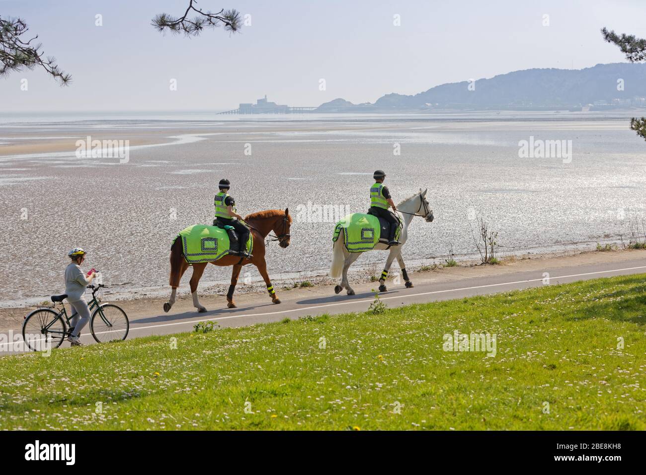 Pictured: Two mounted police officers patrol the path in West Cross by Swansea Bay, Wales, UK. Friday 10 April 2020 Re: Easter Weekend, Covid-19 Coron Stock Photo