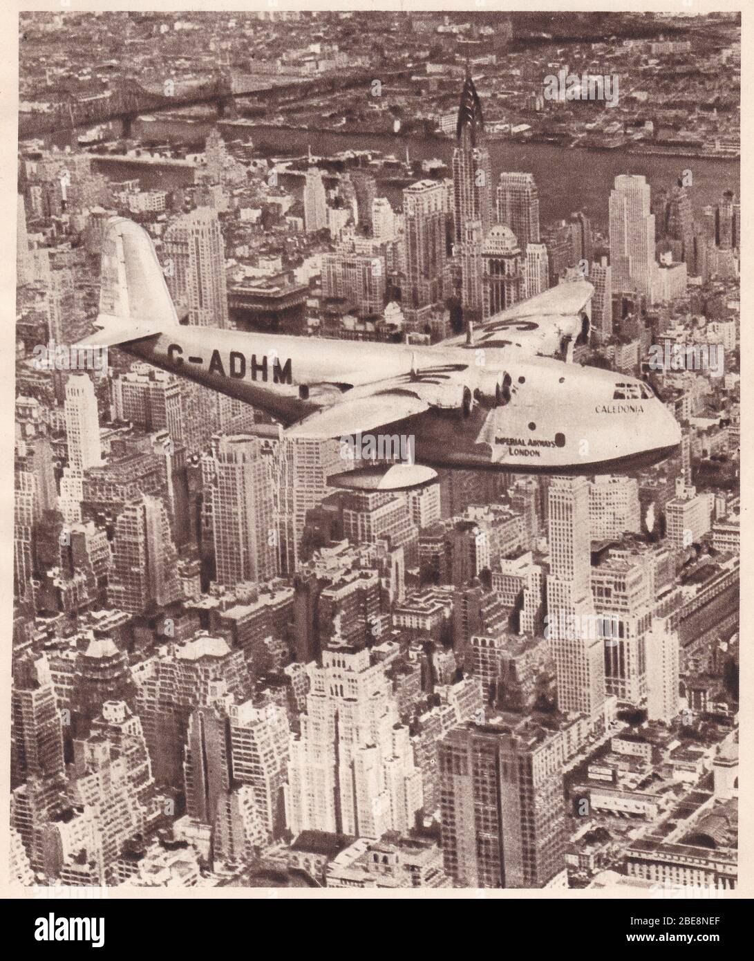 Vintage 1930s black and white photo of the Empire flying-boat Caledonia of Imperial Airways flying over New York, USA. Stock Photo