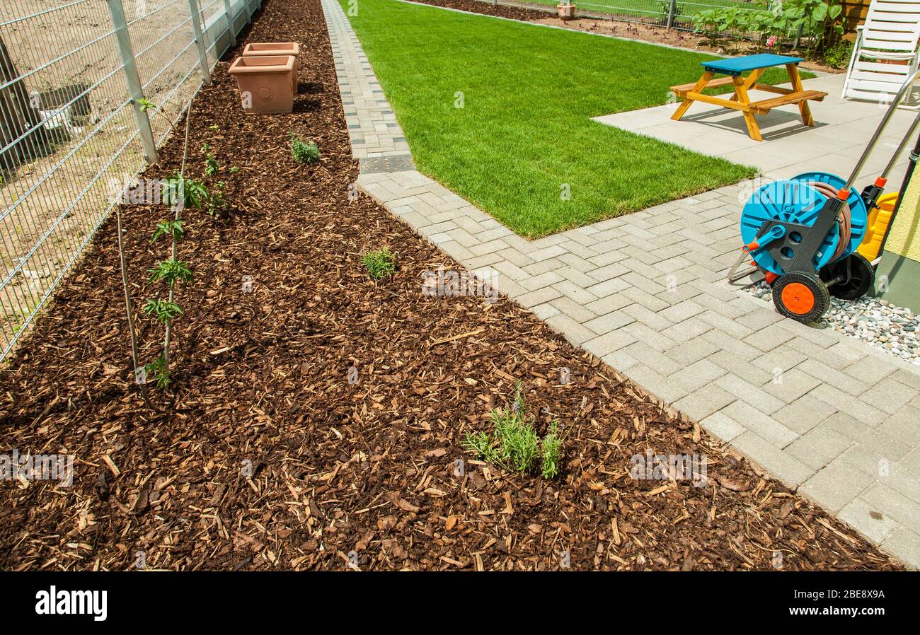 Gardening Garden with fresh new lawn and bark mulch area to reduce