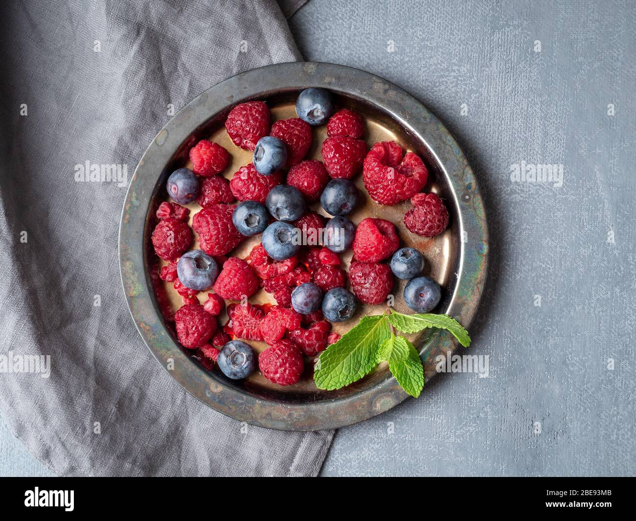Blueberries and raspberries on plate. A mix of berries on dark background Stock Photo
