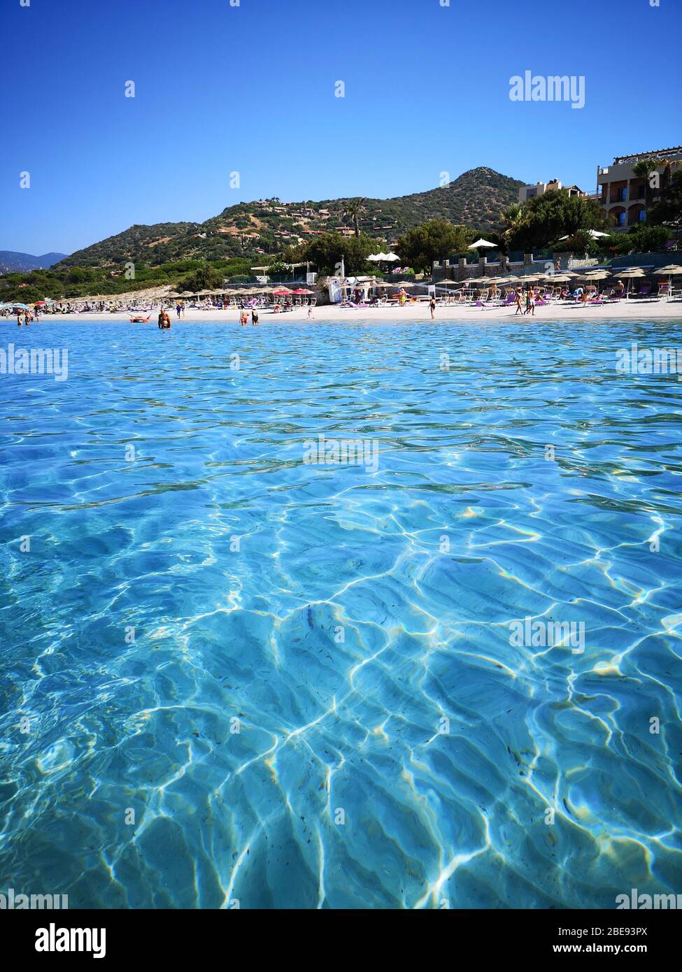 Villasimius, Italy - August 10, 2019: Blue and transparent water and the light sand of a beach in Sardinia. Stock Photo