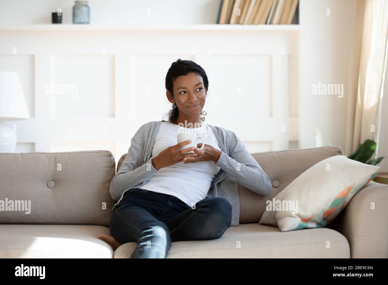 Young calm african american girl sit on sofa Stock Photo - Alamy