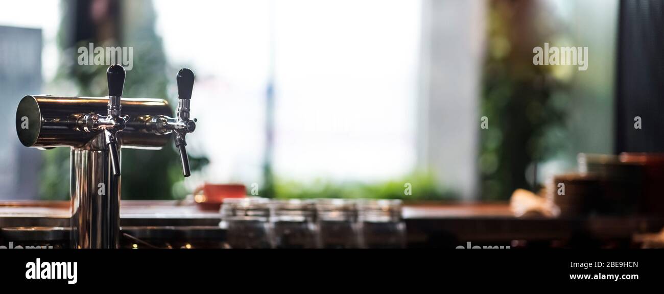 Selective focus on cold beer tap in cafe, blurred background Stock Photo