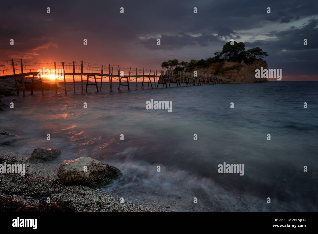 Beautiful sunrise, just before the storm rains. The famous Cameo island. A beautiful small island with wooden bridge and turquoise water. Zakynthos Stock Photo