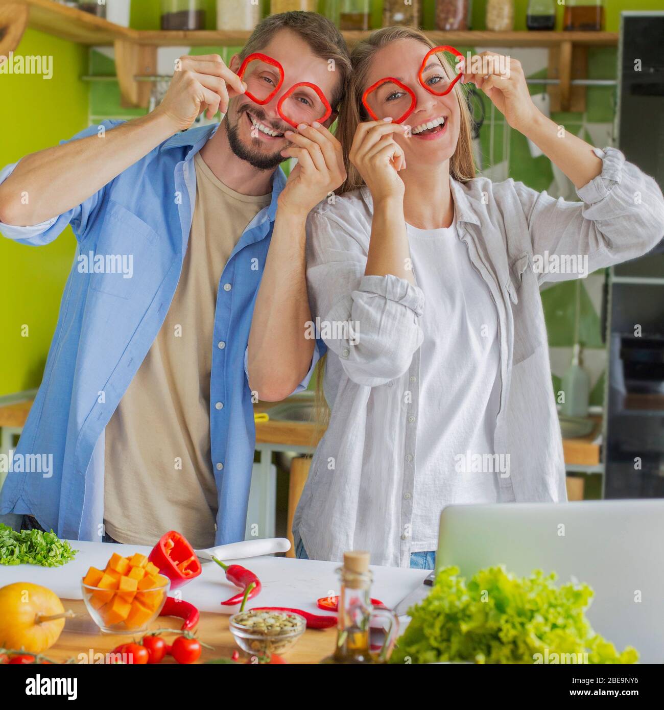 Romantic and funny couple having fun together while making salad Stock Photo