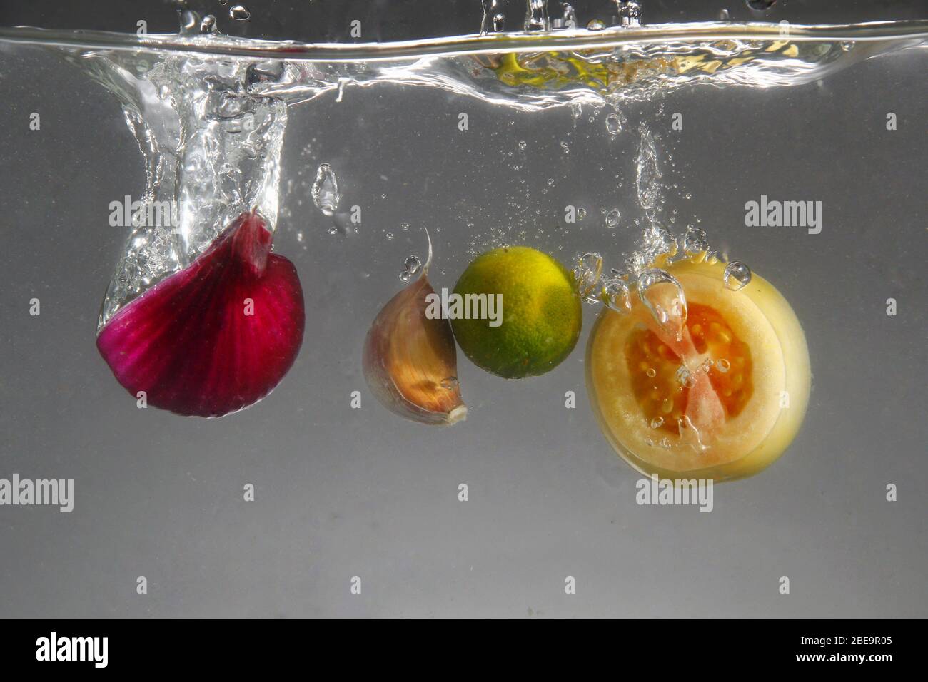 Photo of red onion, garlic, tomato and calamansi dropped in water Stock Photo