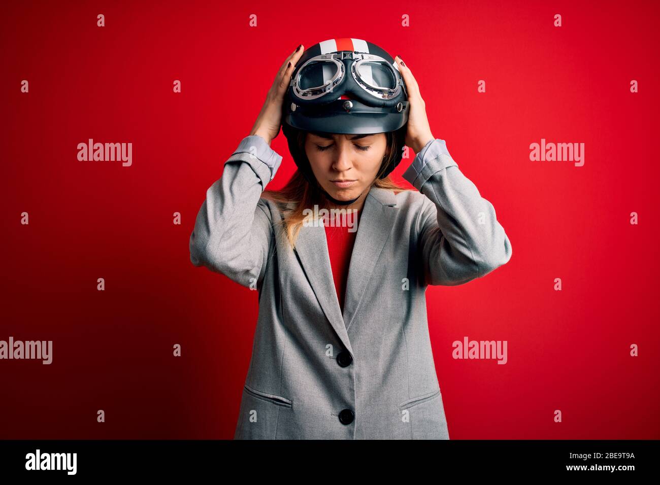 Young beautiful blonde motorcyclist woman wearing motorcycle helmet