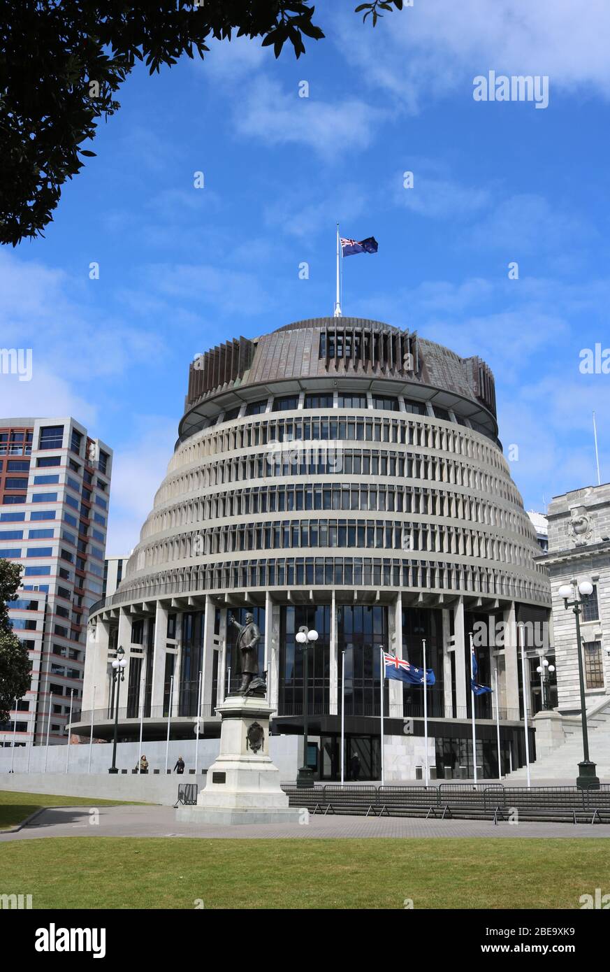 Flags flying outside and on the Beehive, the Executive Wing of New Zealand Parliament buildings in Wellington, North Island, New Zealand. Stock Photo