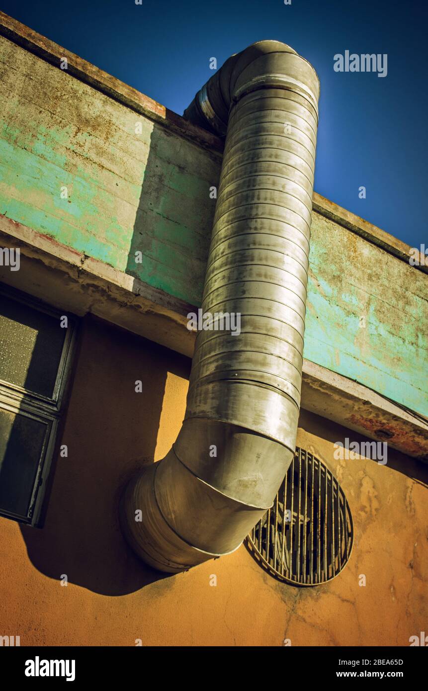 Industrial detail of a ventilation pipe in an old building wall Stock Photo