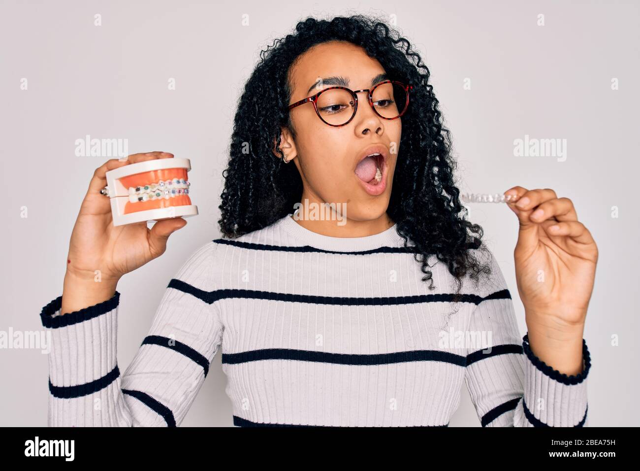 Young beautiful african american woman with curly hair wearing glasses ...