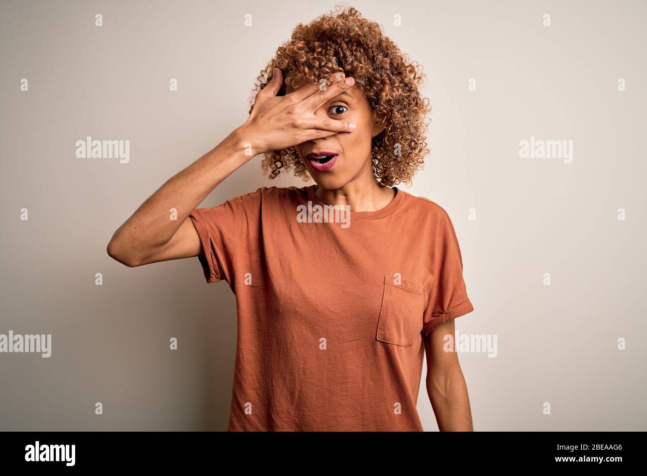 Beautiful african american woman with curly hair wearing casual t-shirt ...