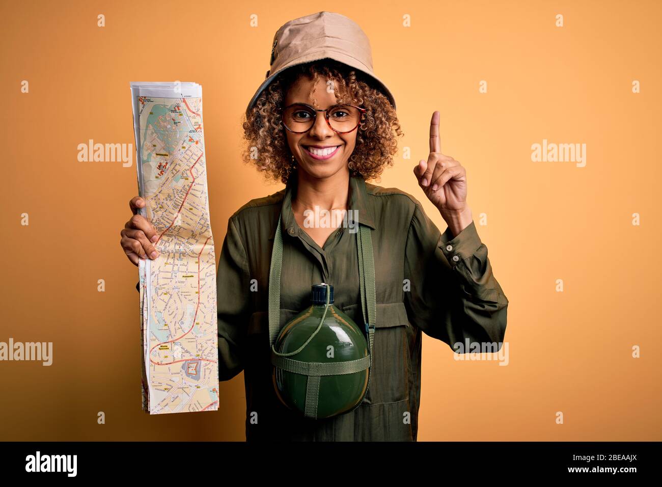 African american tourist woman wearing explorer hat and water canteen ...