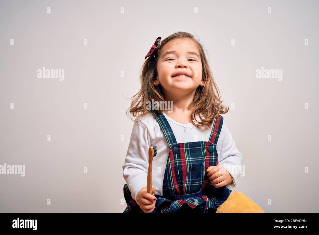 Young little infant girl brushing her teeth using tooth brush and oral paste, cleaning teeth and tongue as healthy health care morning routine. Learni Stock Photo