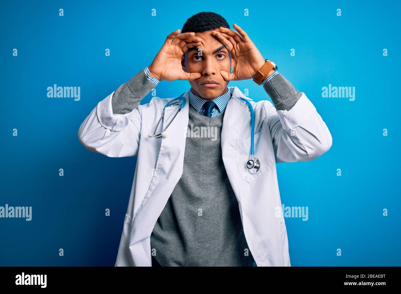 Handsome African American Doctor Man Wearing Coat And Stethoscope Over Blue Background Trying To