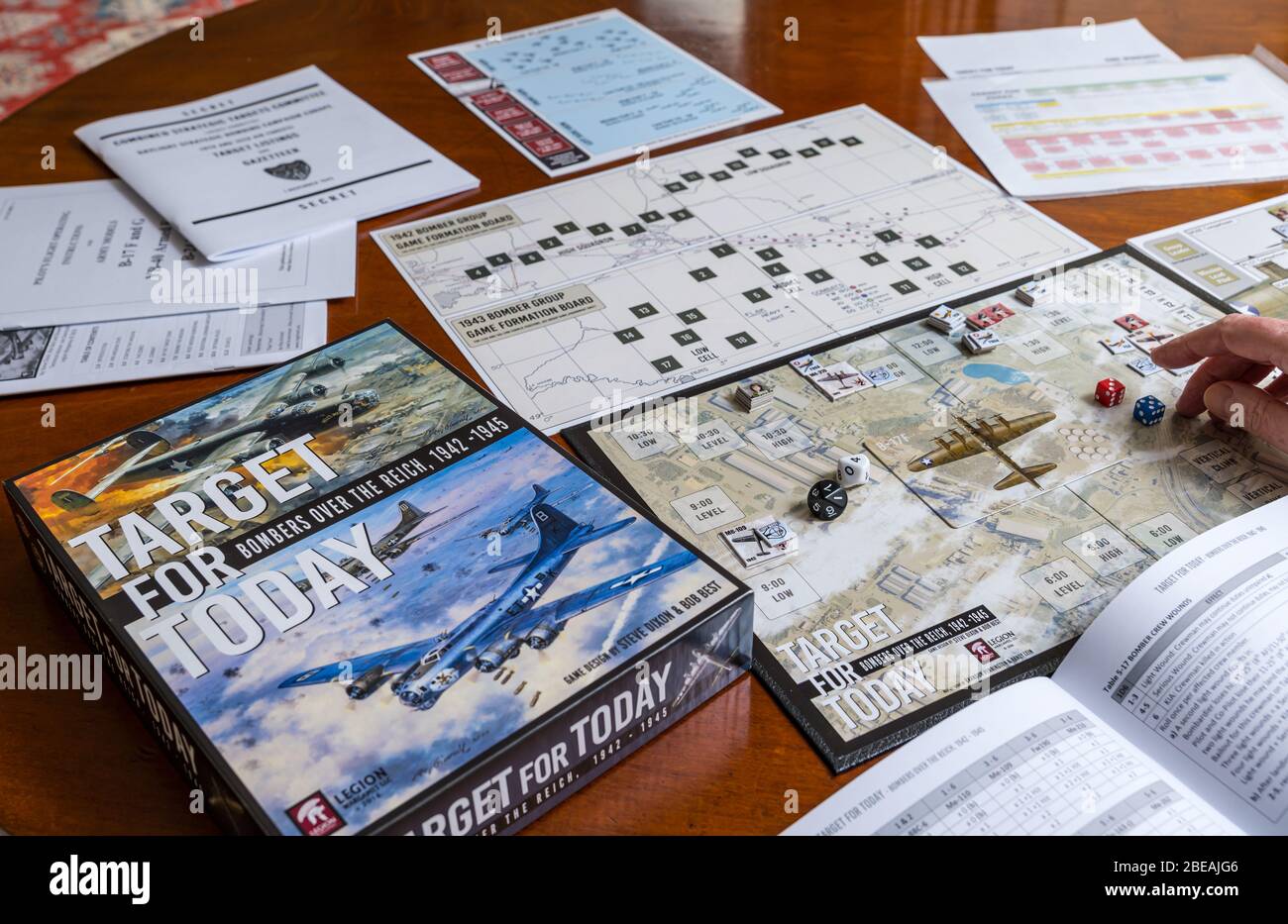 Senior man playing one player solitaire war board game called Target for Today set up on dining table in home, UK Stock Photo