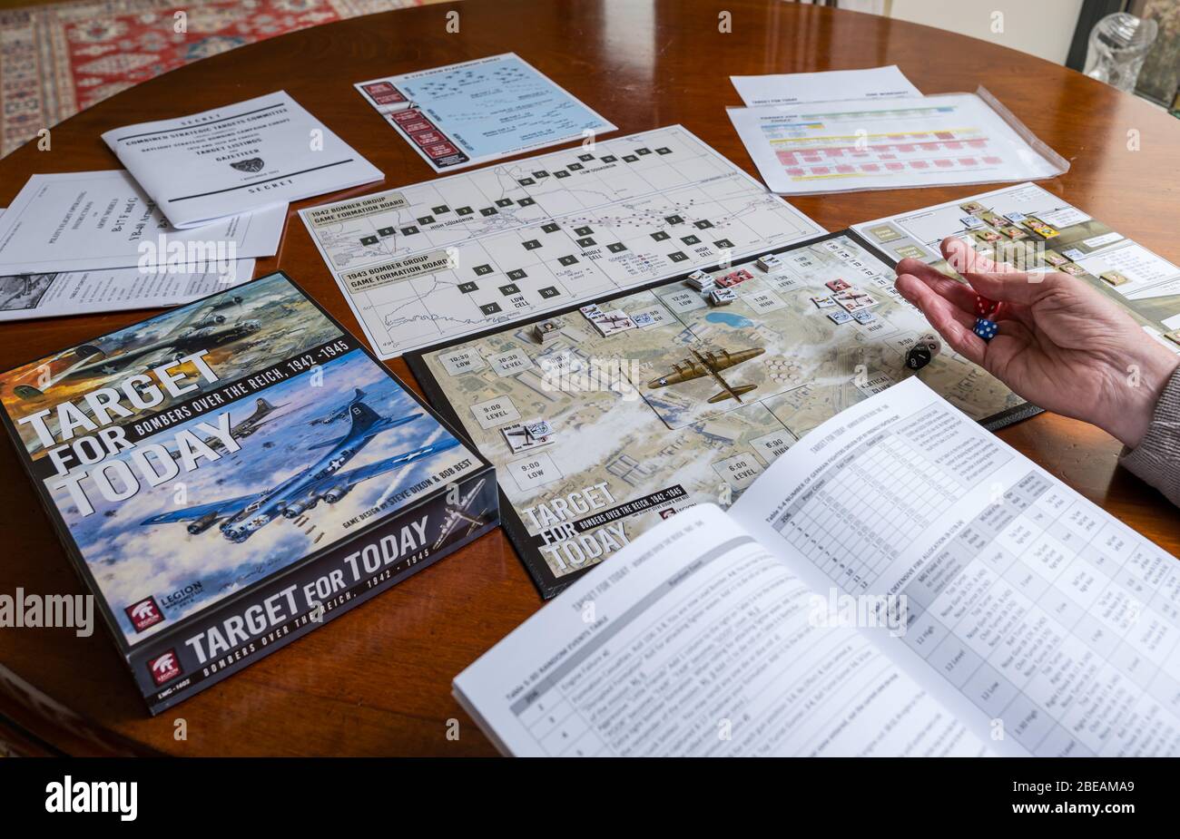 Senior man playing one player solitaire war board game called Target for Today set up on dining table in home, UK Stock Photo