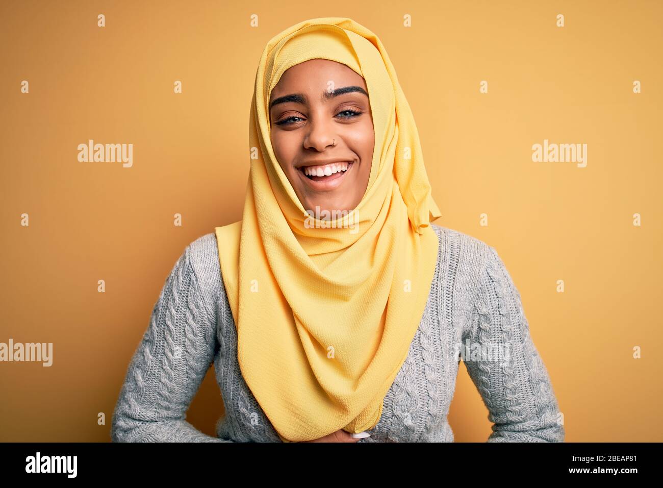 Young beautiful african american girl wearing muslim hijab over isolated  yellow background smiling and laughing hard out loud because funny crazy  joke Stock Photo - Alamy