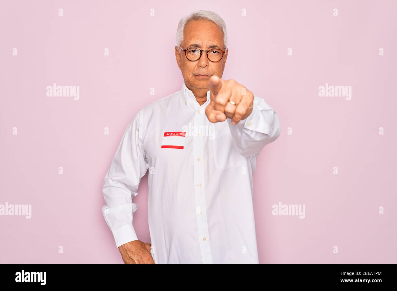 Middle age senior grey-haired man wearing hello my name is introduction ...