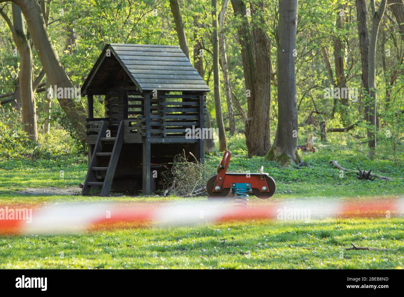 cordoned off playground, surroundet by trees, forcus on background, blurred barrier tape Stock Photo