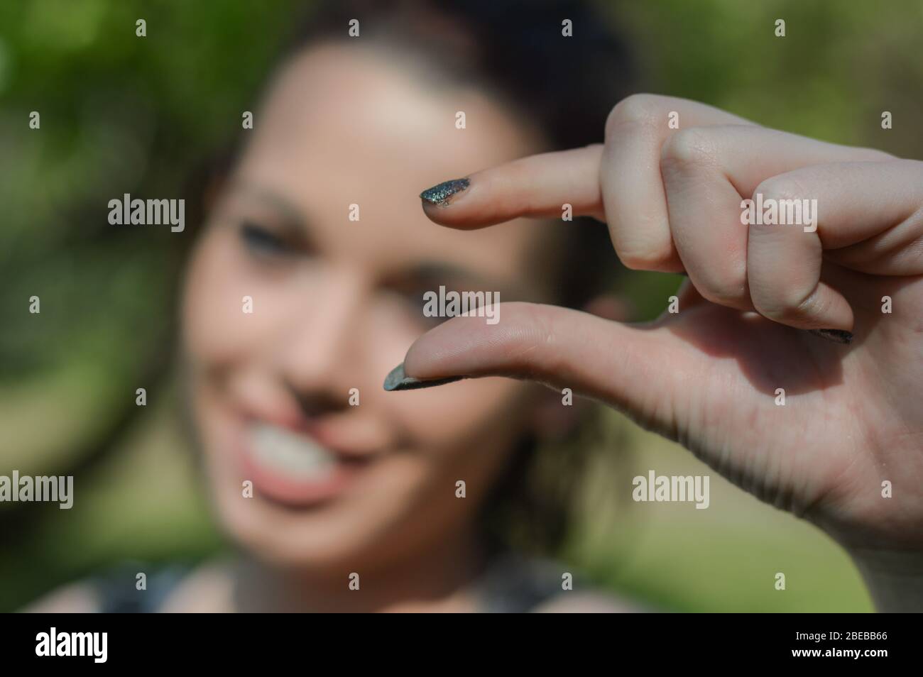 Small hand sign. Young woman doing a sign for a small thing with the ...