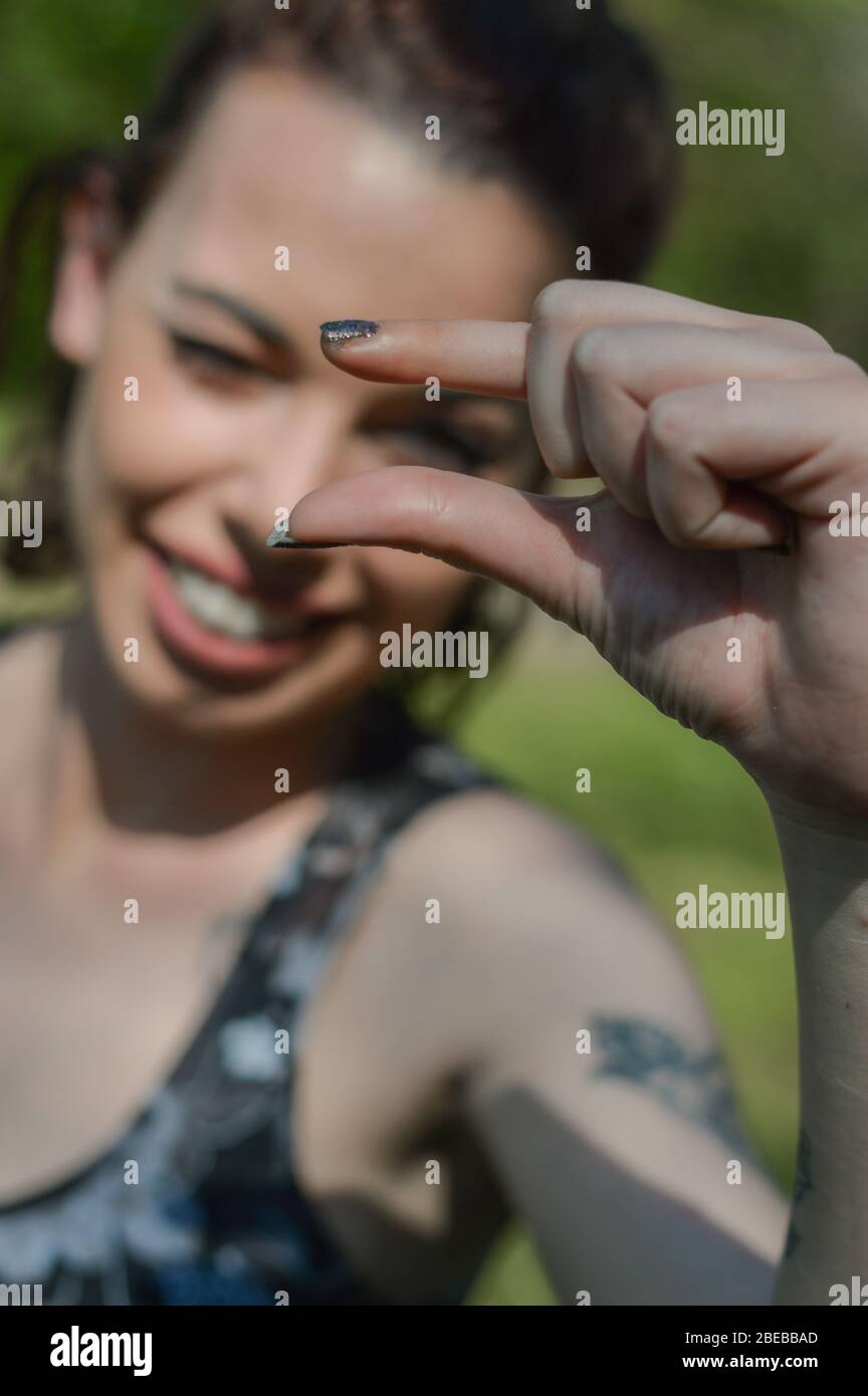 Small hand sign. Young woman doing a sign for a small thing with the ...