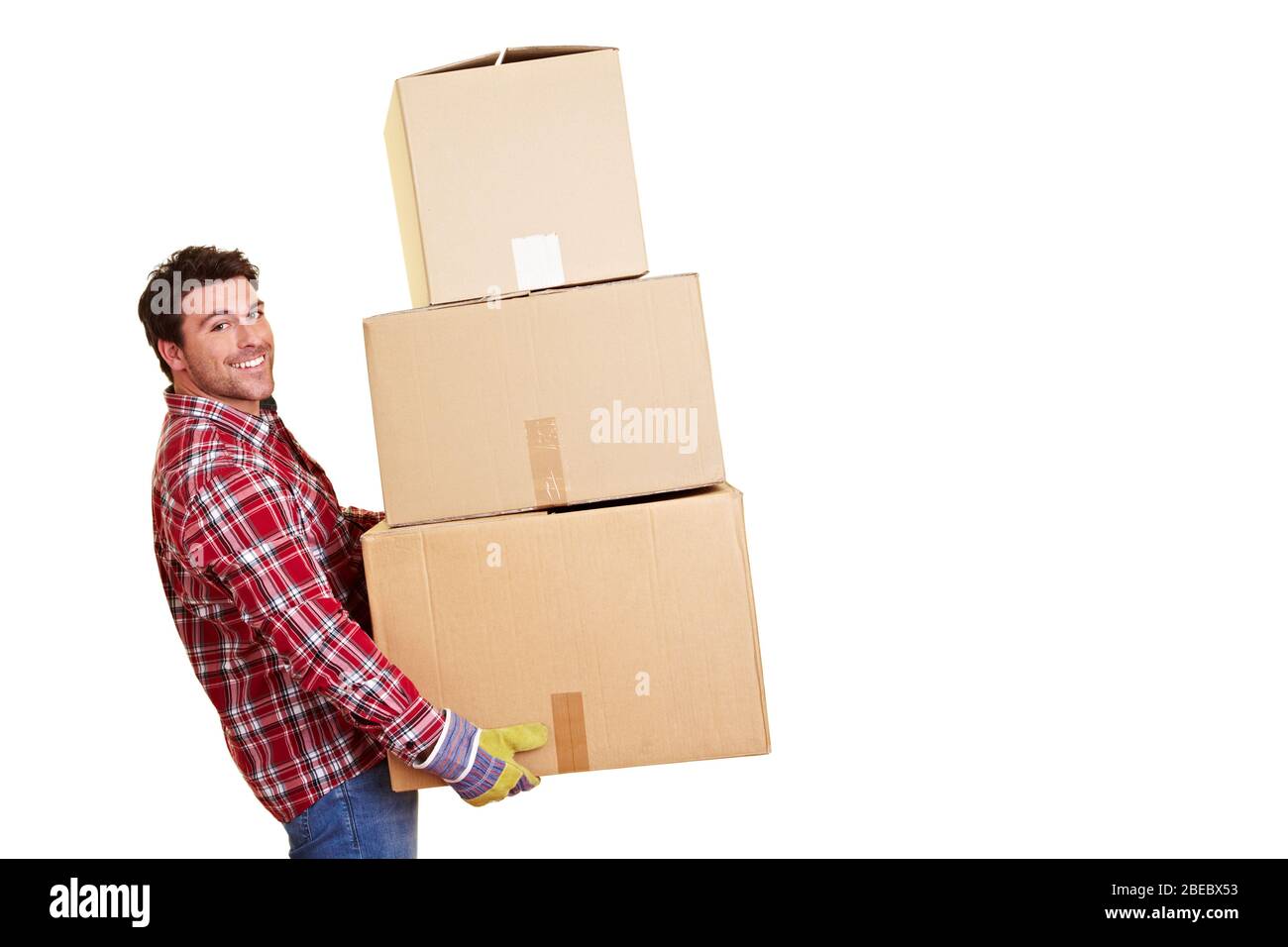 Smiling moving assistant carries a lot of moving boxes Stock Photo