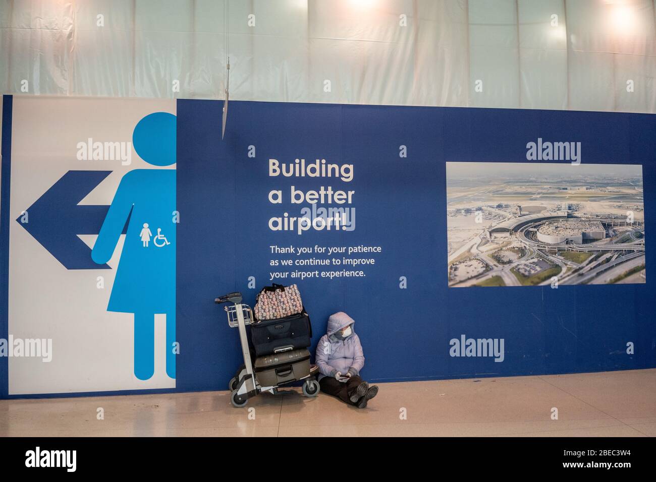 A lady sits in Toronto's Pearson International airport, March 16, 2020. Amid security measures directed at slowing the spread of the COVID-19 virus, Canada's Prime Minister Justin Trudeau restricted travel to Canada, from many international countries. Pearson will be one of the designated airports in Canada that will be allowed to accept limited international flights. Stock Photo