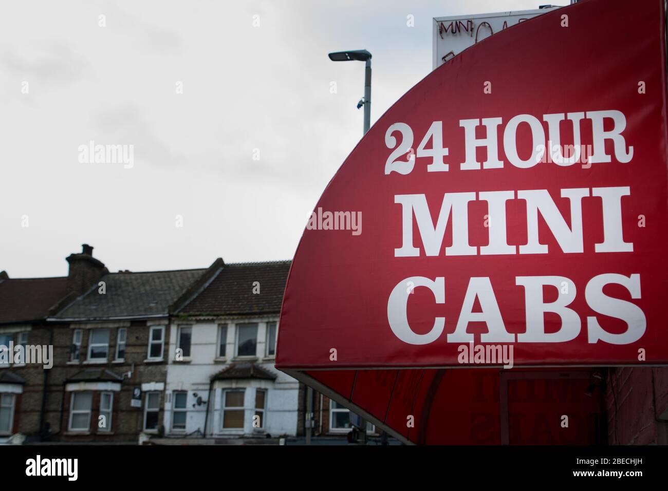 UK high street '24 hour mini cabs' signage Stock Photo