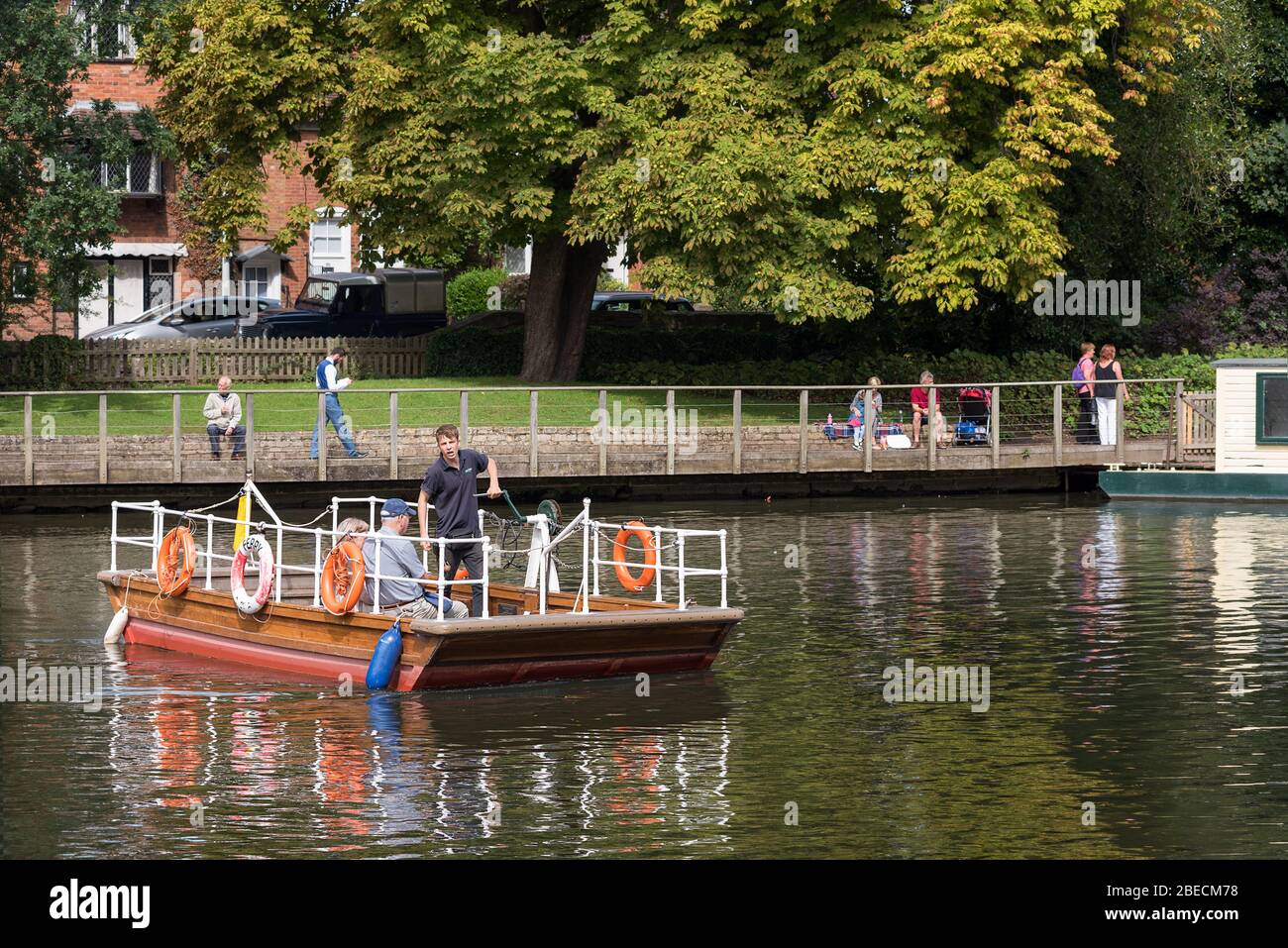 The operator manually powers the Stratford on Avon chain ferry crossing the river Avon. Stock Photo