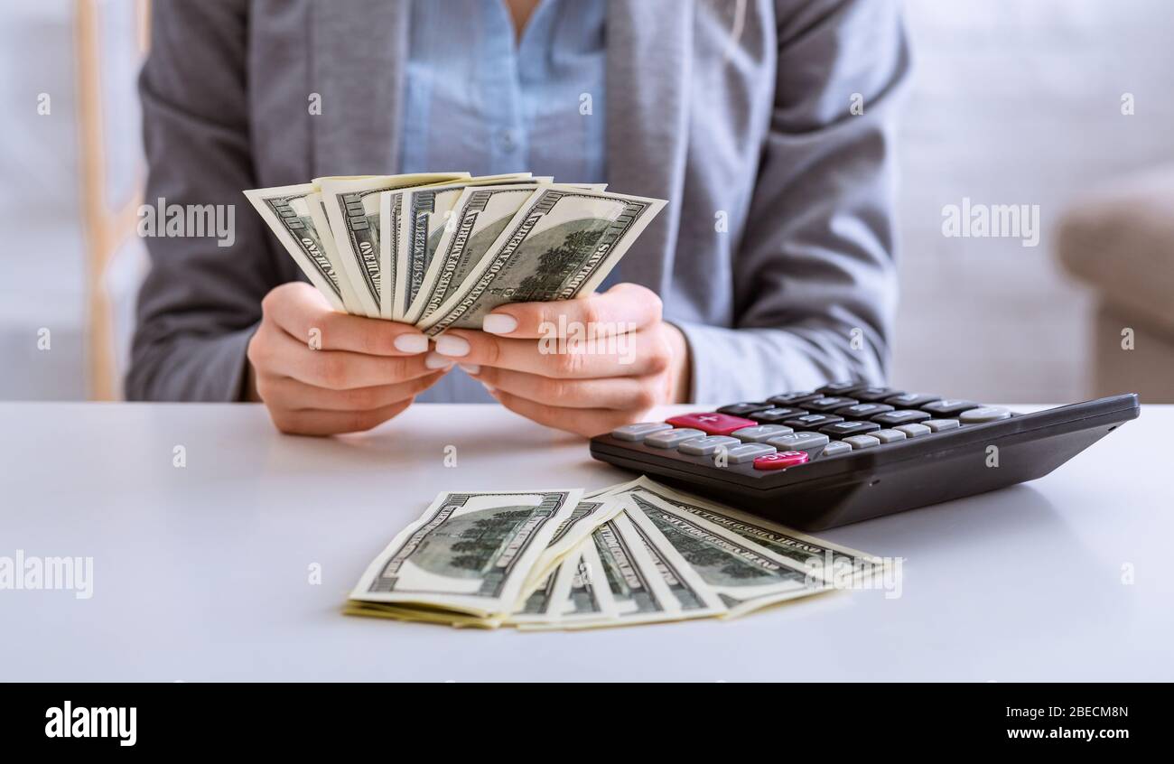 Budget planning in crisis. Female hands consider dollars Stock Photo