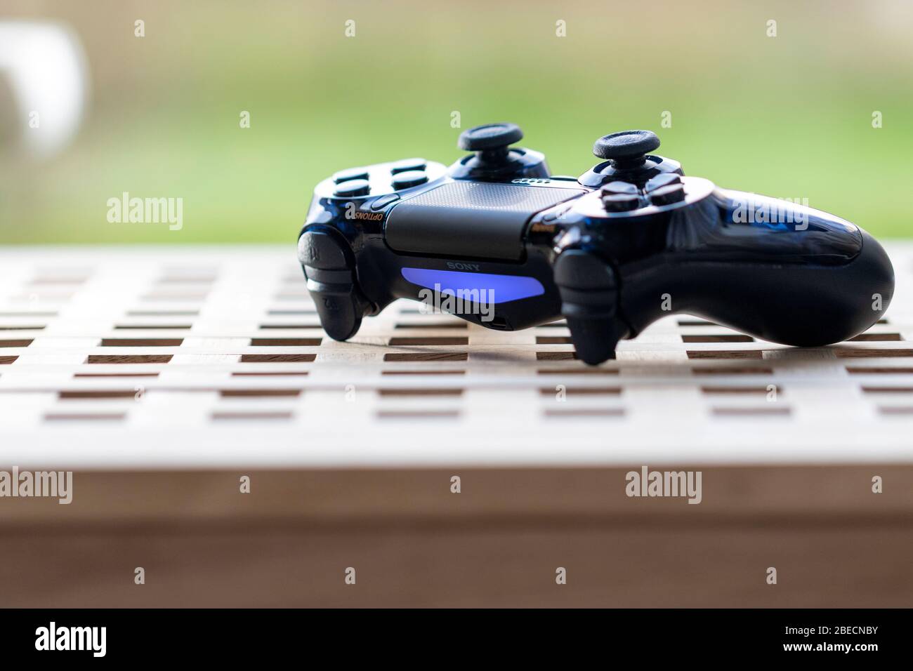 Brecht, Belgium - Februari 1 2020: A portrait of a turned on wireless sony playstation  4 controller lying on a wooden table. The device is ready to st Stock Photo  - Alamy