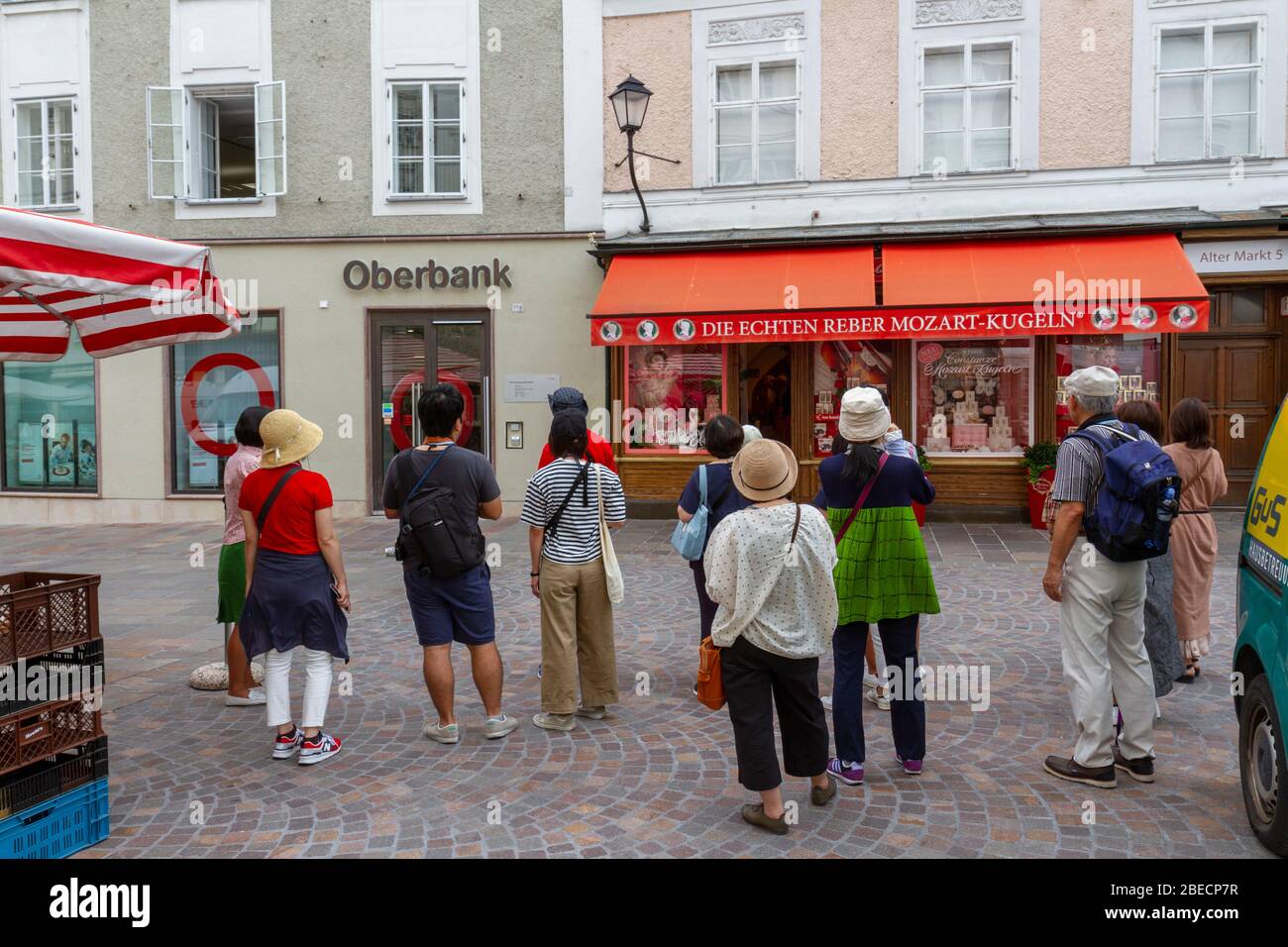 Tourists standing outside the Constanze Mozart Kugel (original) confectionery store selling Mozartkugel (Mozart ball), Salzburg, Austria. Stock Photo