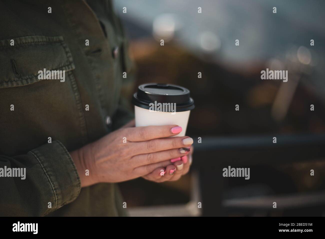 The girl is holding a disposable paper Cup of coffee. Stock Photo