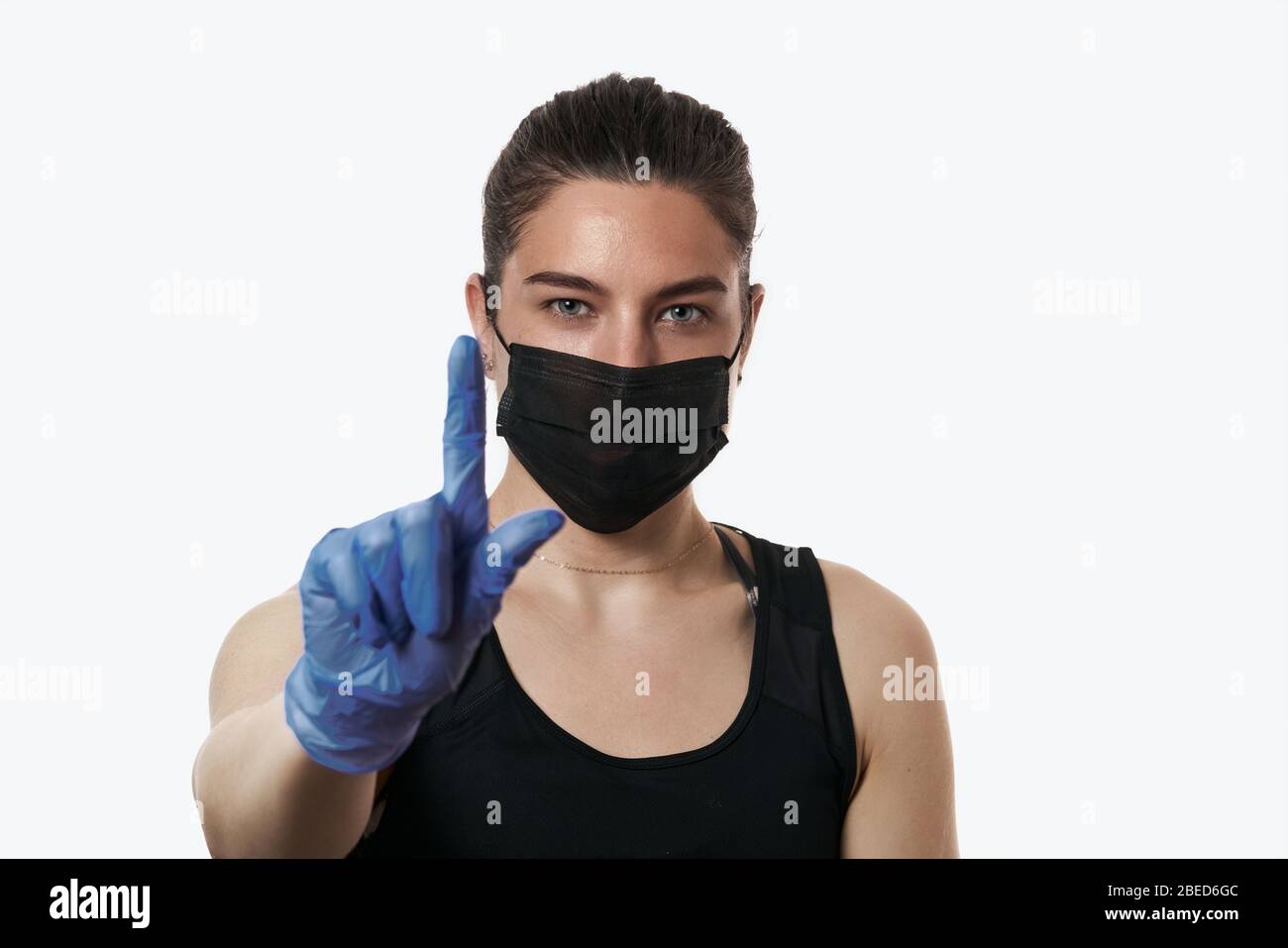 Girl in a protective mask and gloves. Coronovirus protection pandemic, covid-19. Head and shoulders portrait of female wearing protective mask posing Stock Photo
