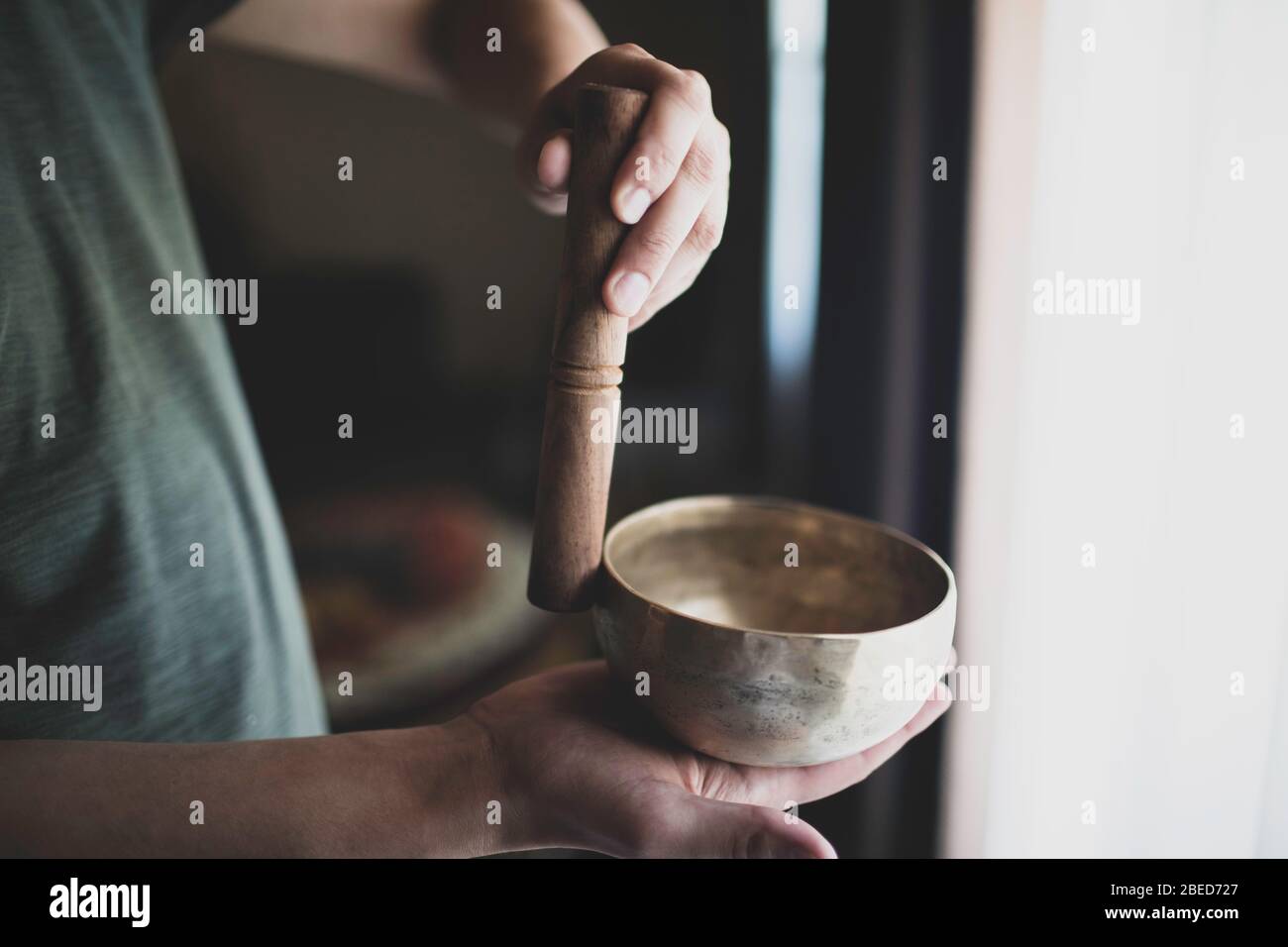A man reproduces a singing bowl for meditation. Stock Photo