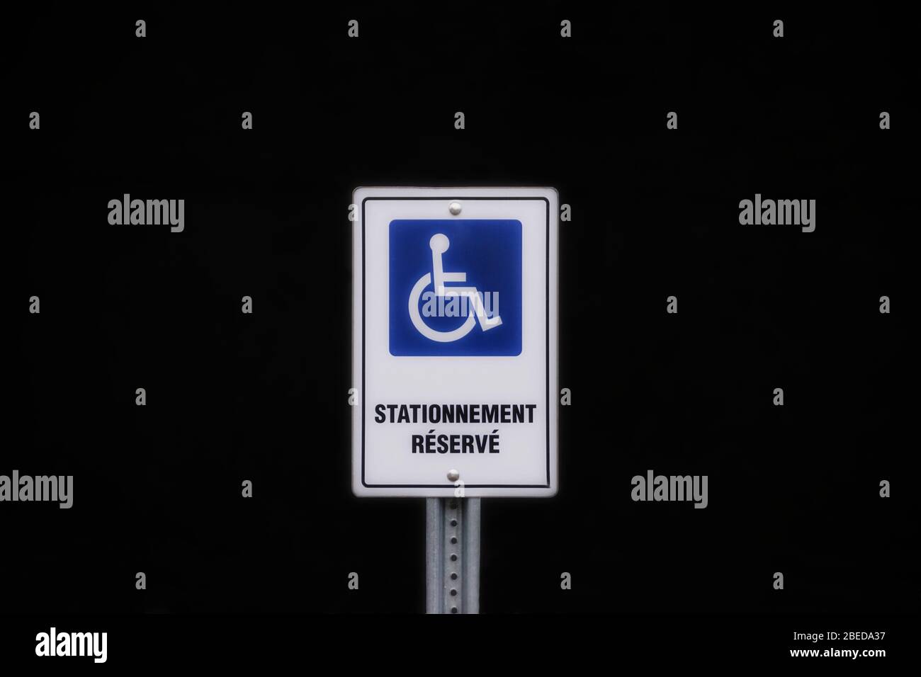 Symbol of handicap disabled parking space on a black background written in french Stock Photo
