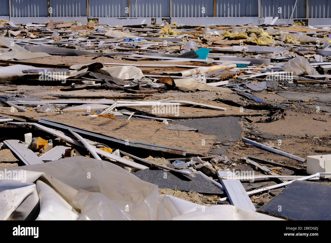 Construction garbage, cardboard, plywood, polyethylene after destruction of small buildings. Removal of debris. Bunch of trash. Stock Photo