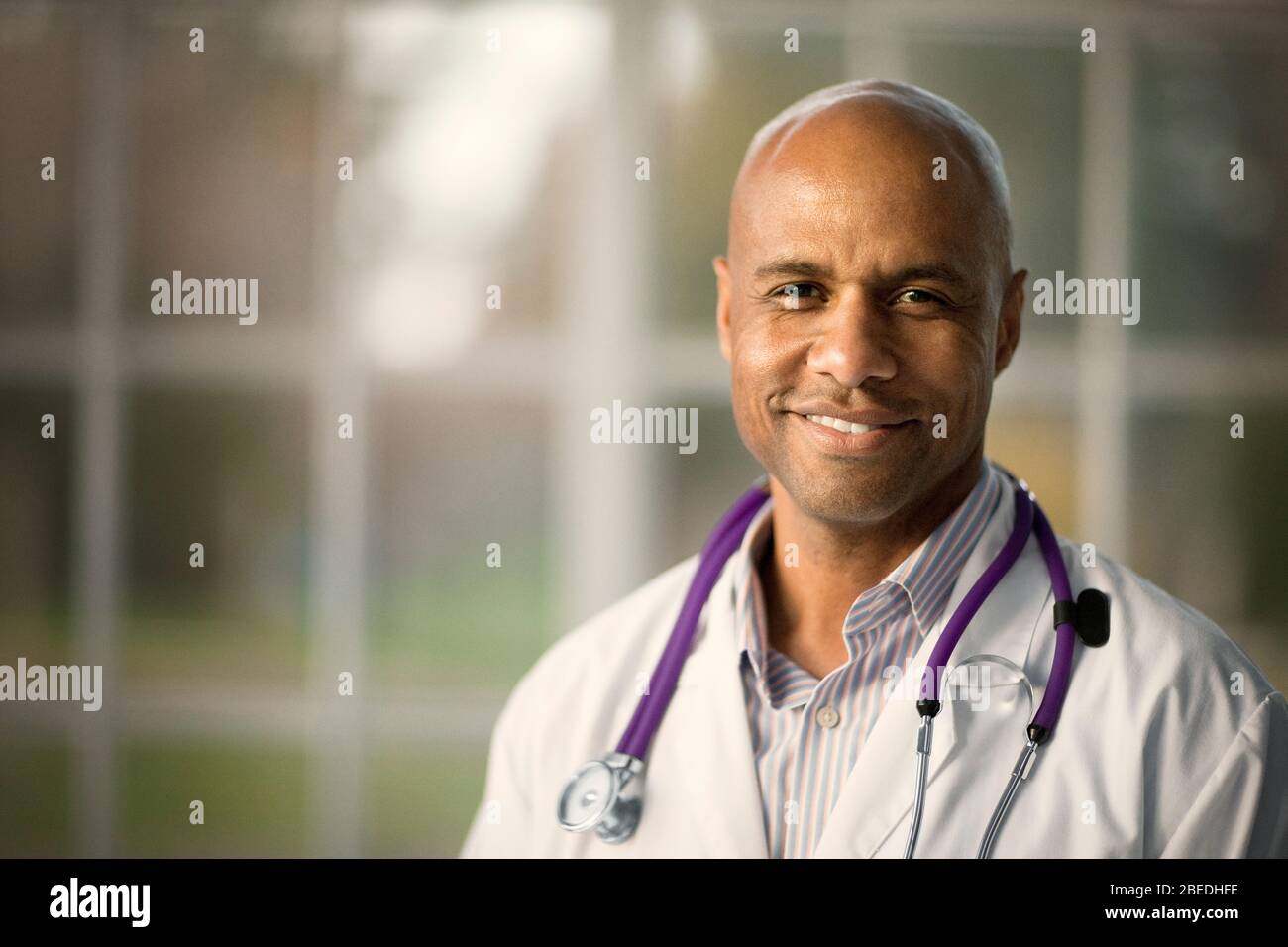 Smiling young doctor stands hi-res stock photography and images - Alamy