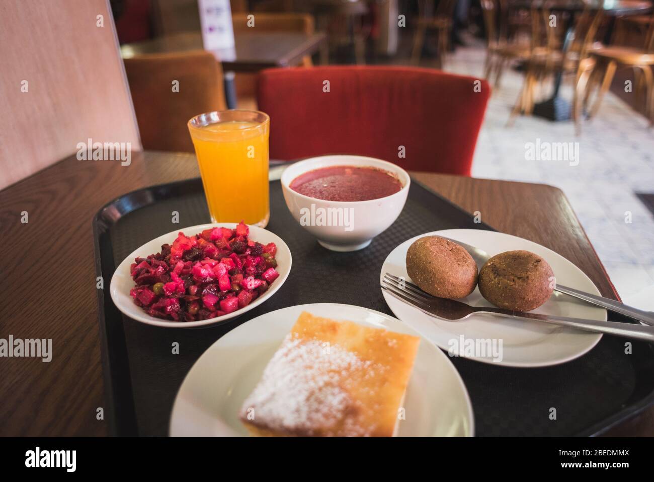 Meal at budget restaurant in St. Petersburg, Russia for 2.3 US dollar: vinegret, sea buckthorn drink, borscht, rye bread, tvorozhnik. Stock Photo