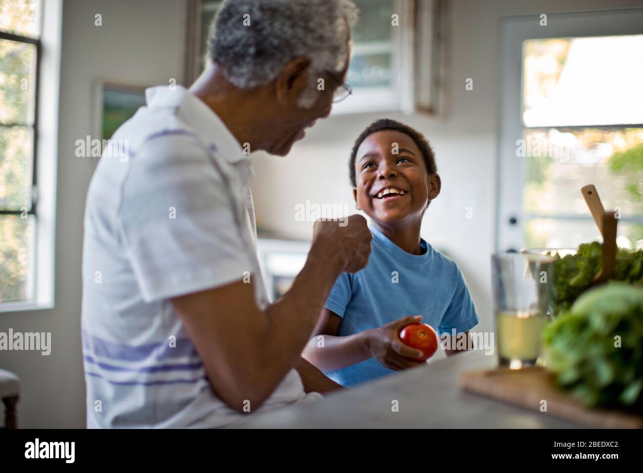 Grandfather and grandson preparing food together Stock Photo