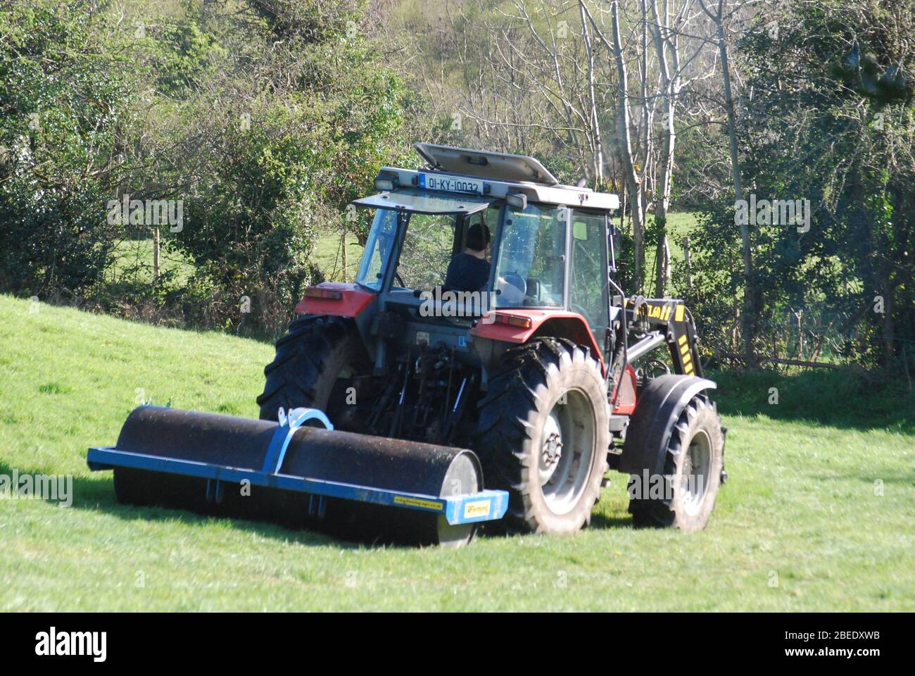 Farmer rolling field in Slaheny, Kilgarvan, Co. Kerry Stock Photo