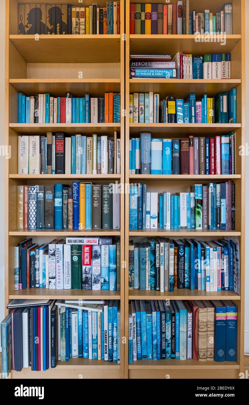 Bookshelves full of books in a home; fiction, non-fiction, history, dictionaries, hill walking, outdoor activities, UK Stock Photo