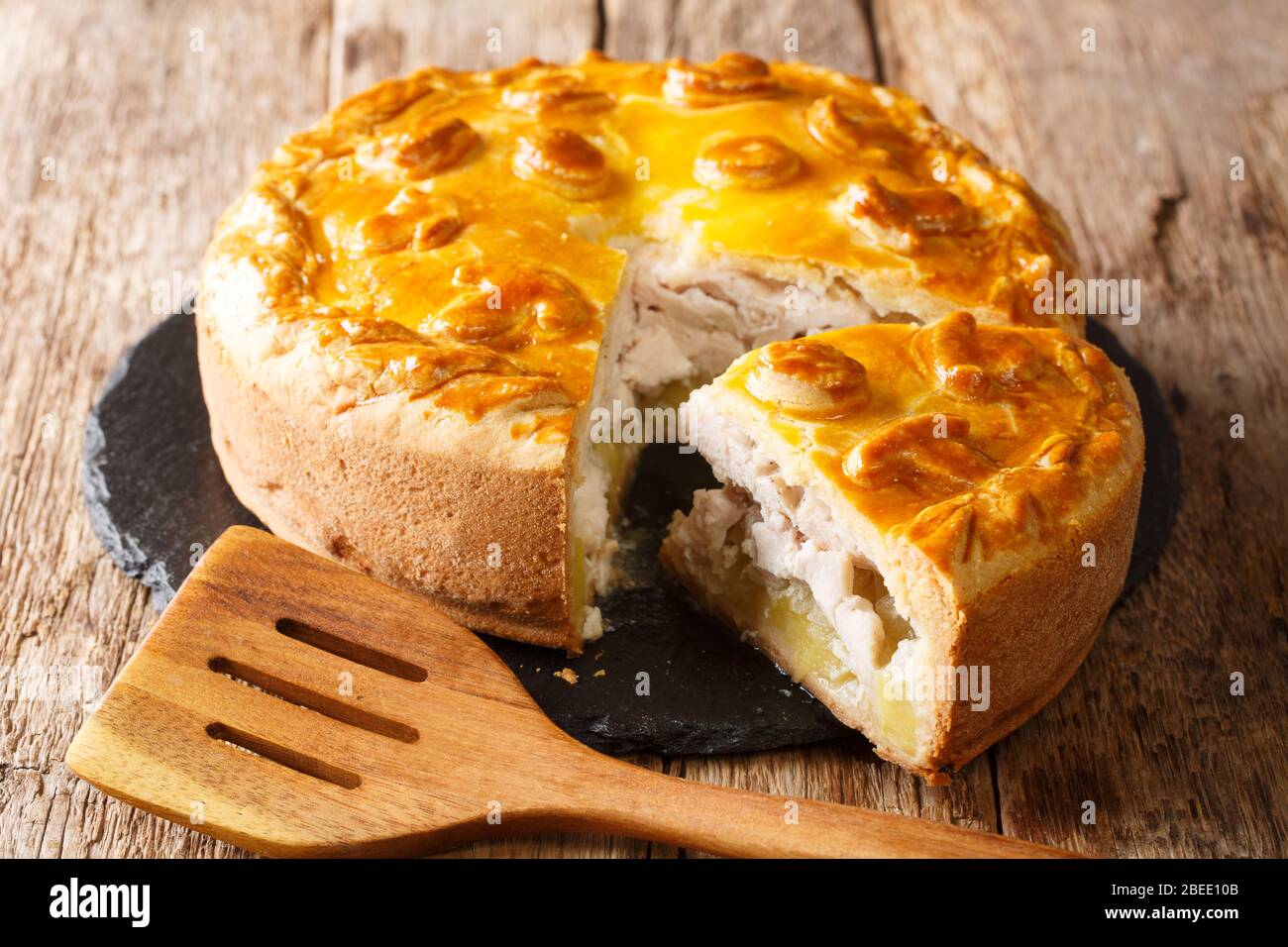 Traditional savory pie kurnik with chicken, potatoes and rice. Homemade  baking. Vertical view Stock Photo