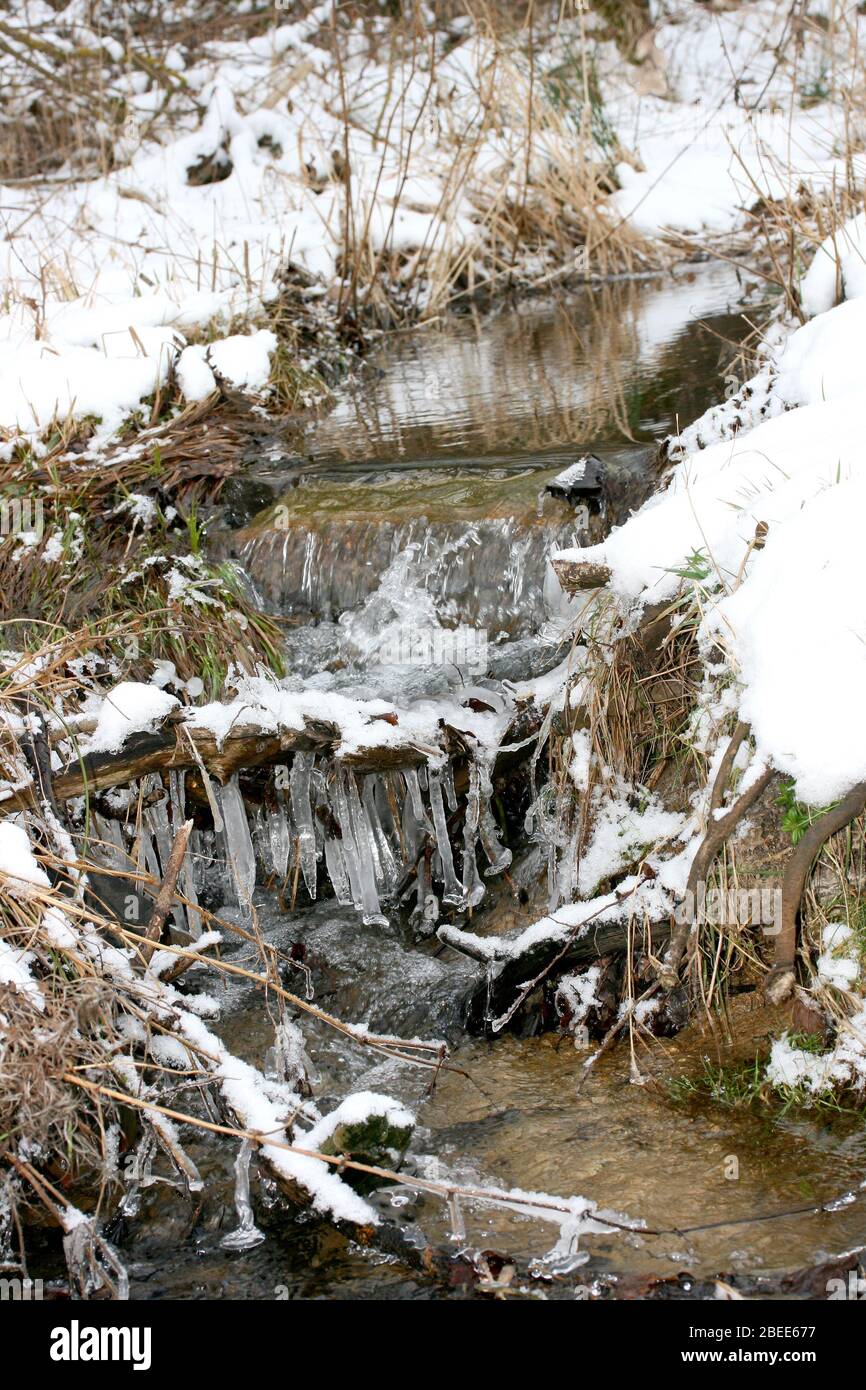 A small winter Creek with icicles Kleiner winterlicher Bachlauf mit Eiszapfen Stock Photo