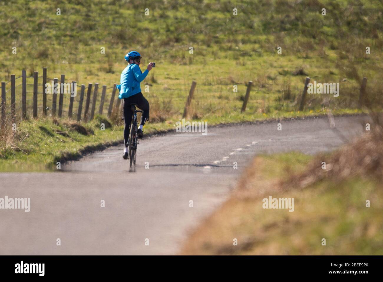 Cumbernauld, UK. 13th Apr, 2019. Pictured: A road cyclist is seen taking a selfie whilst out riding his bike during the Lockdown on a bright and hot sunny Spring Bank Holiday Easter Monday. Due to the UK wide Coronavirus (COVID-19) Lockdown imposed by both the UK and Scottish Governments, police have been enforcing the lockdown and people have been taking the warning seriously with all tourist and beauty hotspots being cordoned off with road blocks. Credit: Colin Fisher/Alamy Live News Stock Photo