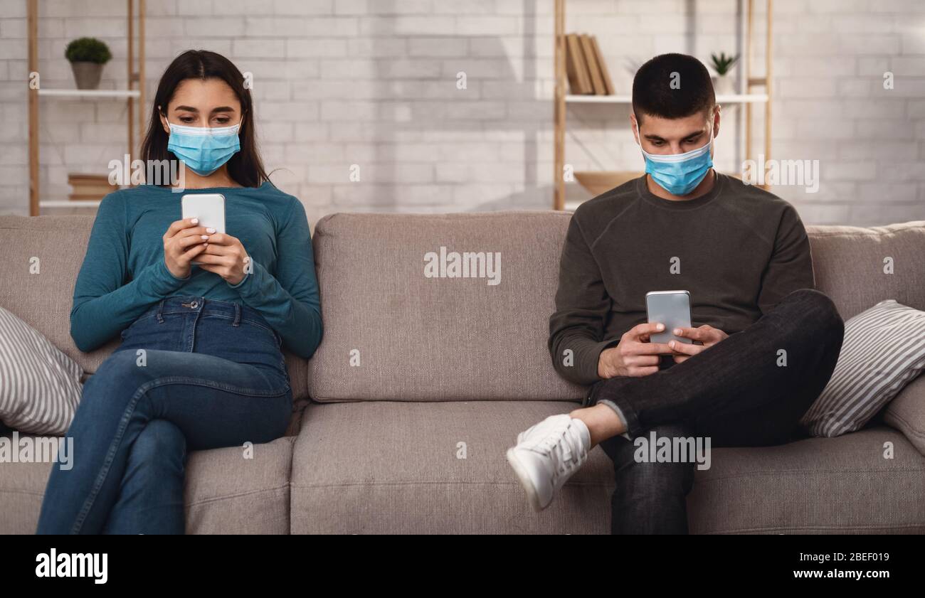 Couple wearing surgical mask using smart phone Stock Photo
