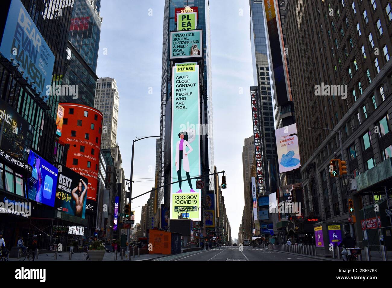 New York City, USA. 12th Apr, 2020. A mostly deserted Times Square in Manhattan during the pandemic of the novel coronavirus disease (COVID-19). The board in the centre shows a message reading "Please, avoid close contact with people who are sick". As of 13 April 2020, the United States has confirmed more than 560,000 confirmed cases of the novel coronavirus infection, with more than 104,000 confirmed cases in New York City. Credit: Maria Khrenova/TASS/Alamy Live News Stock Photo
