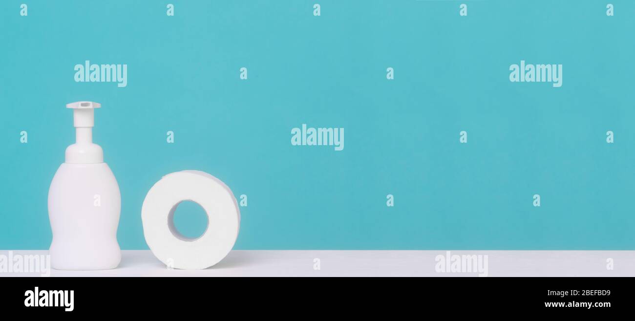 Hand sanitizer bottle or alcohol gel and paper towel on blue background