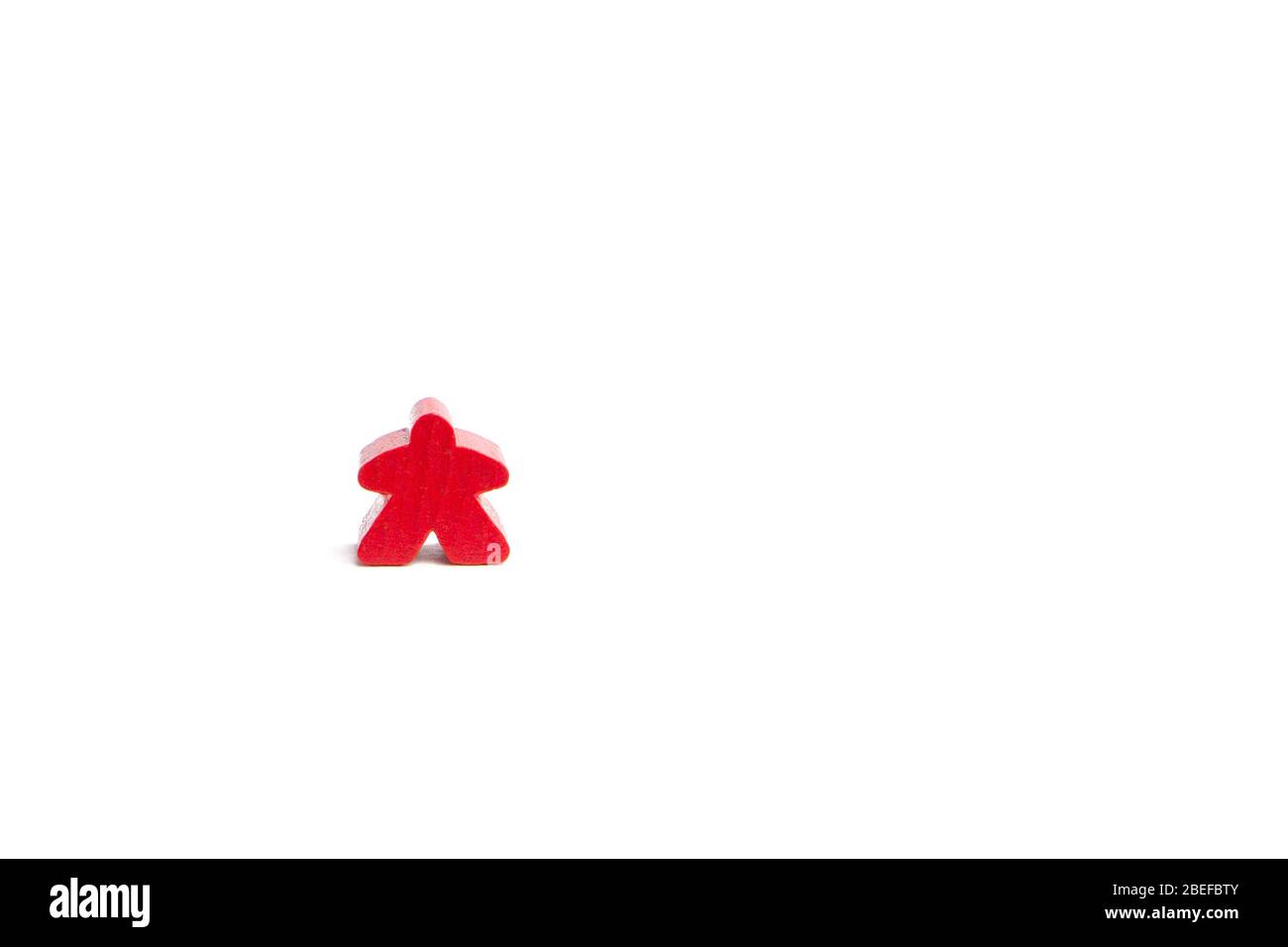 Red figure is isolated on a white background. Alone in the world concept. Carcassonne game component. Stock Photo